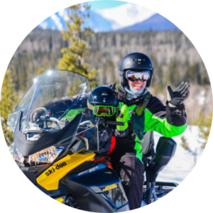 Zeb and son are all smiles astride a snowmobile together, thinking about the full range of services Zebulon LLC offers.